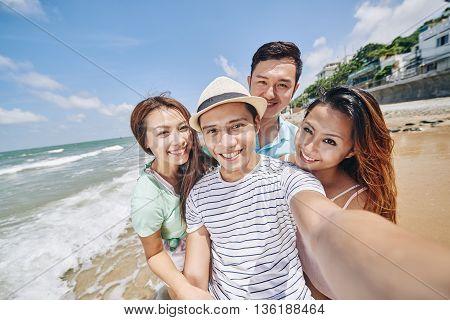 Asian smling young people taking selfie at the beach