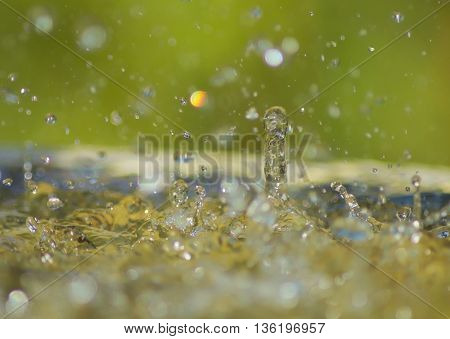 Heavy rain splashes into water creating rebounding water droplets