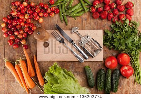 Italian food background, with vine tomatoes, basil, spaghetti, mushrooms, olives, parmesan, olive oil, garlic, peppercorns, rosemary, parsley and thyme. Slate background.