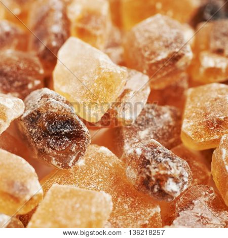 Surface coated with multiple large brown rock sugar crystals as a background composition