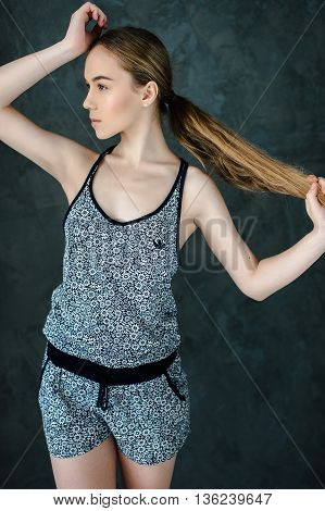 sports girl with a good body goes in for sports and youga on a dark background