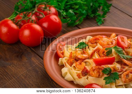 Fettuccine Pasta With Shrimp Tomatoes And Herbs. Wooden Background
