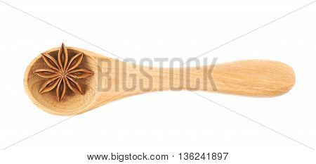 Chinese star anise seed served in a wooden spoon, composition isolated over the white background