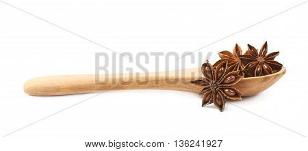 Chinese star anise seed served in a wooden spoon, composition isolated over the white background