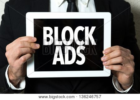 Business man holding a tablet with the text: Block Ads