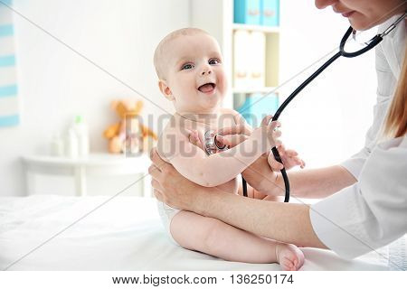 Professional pediatrician examining infant