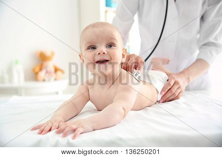 Professional pediatrician examining infant