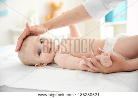 Doctor doing exercises with baby