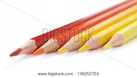 Line of five color pencils, composition isolated over the white background, close-up crop fragment composition