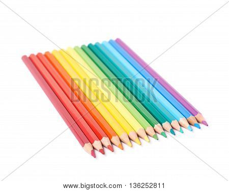Multiple colorful color pencils composition arranged in a line to form a rainbow gradient, composition isolated over the white background