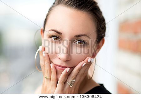 Portrait of young girl with hands in face
