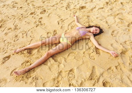 Girl lying on the sand, on the beach