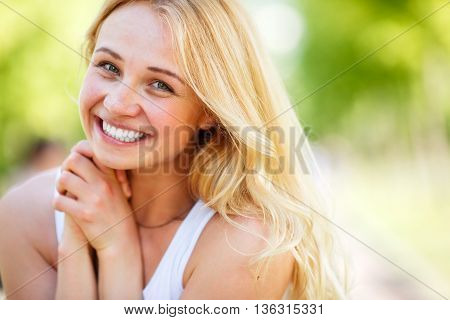 Caucasian attractive smiling blond woman with toothy smile and hands in lock