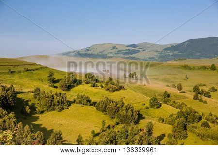 Colorful morning mist up the hills in the Romanian Apuseni Mountains near Salciua