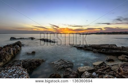 Sunset over old pier in the sea in south Athens, Greece