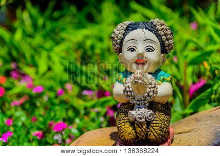 Thai stucco doll Sawasdee in the garden.