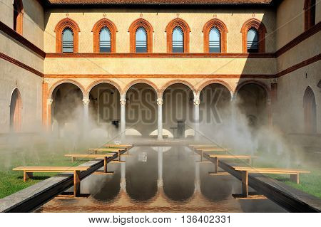 Middle Ages courtyard with pool in surreal fog