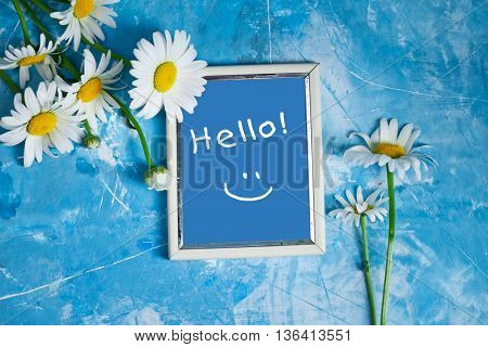Summer Floral card with chamomile flower over blue vintage painted wooden background.