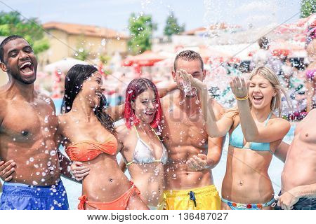 Young friends having fun in water park on vacation - Multi ethnic couples playing together in swimming pool on sunny day - Enjoying summer time concept - Soft focus on blond girl - Warm filter look