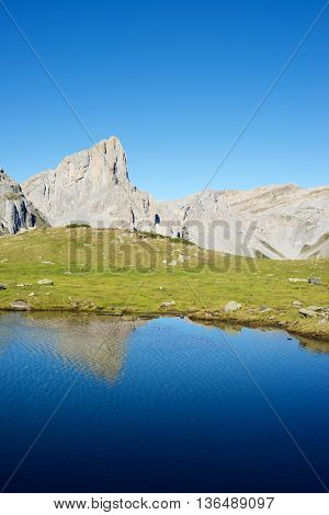 Peaks reflected in Ansabere Lake. Lescun Cirque. Aspe Valley, Pyrenees, France.