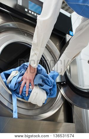 Hands to load the Laundry in the washing machine at the dry cleaners