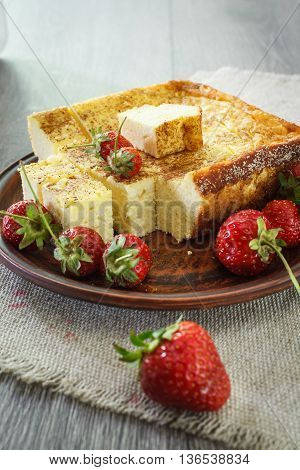 Cheesecake with strawberries. On a wooden table strawberries and linen napkin