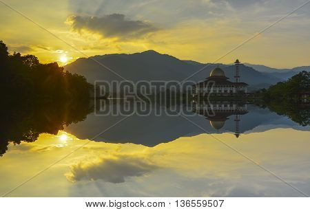 Majestic view of Darul Quran Mosque during sunset with mirror reflection in the lake. Soft focus due to long exposure. Virant colours.