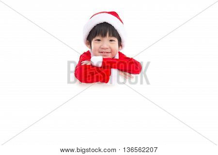 Little asian boy in Santa Claus uniform with an empty banner isolated on white