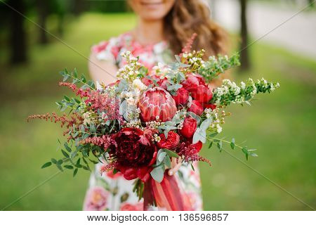 girl in red dress with wedding flowers