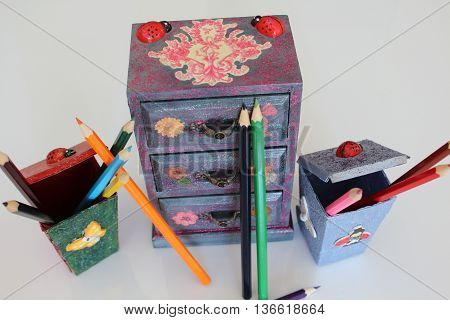 A handmade mini chest of three drawers decoupaged with floral vintage paper handmade objects decorated using different techniques of decoupage