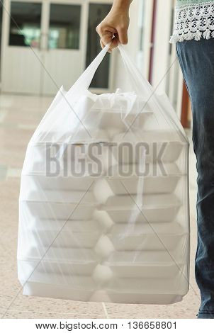Hand holding foam boxes in plastic bag