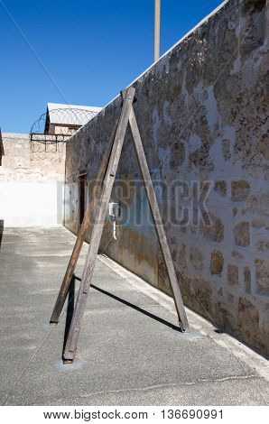 FREMANTLE,WA,AUSTRALIA-JUNE 1,2016:  Fremantle Prison with limestone walls and whipping post under a blue sky in Fremantle, Western Australia.