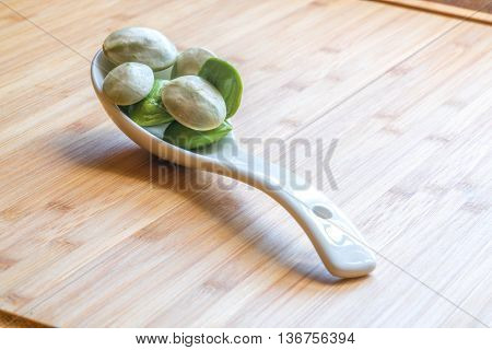 Parkia speciosa ( petai bitter bean twisted cluster bean stinker or stink bean) with white cup and spoon