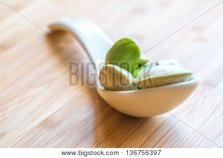 Parkia speciosa ( petai bitter bean twisted cluster bean stinker or stink bean) with white cup and spoon
