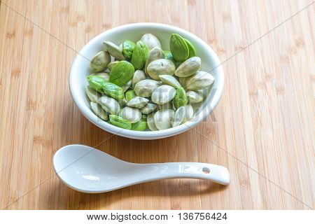 Parkia speciosa ( petai bitter bean twisted cluster bean stinker or stink bean) with white cup and spoon