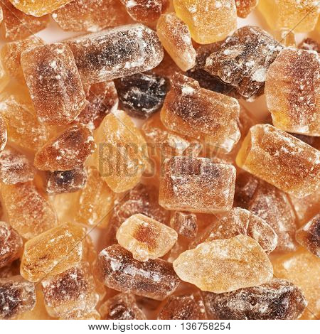Surface coated with multiple large brown rock sugar crystals as a background composition