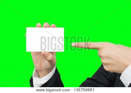 Hand holding and pointing blank business card for copyspace isolated on green background with clipping path