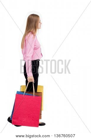 ack view of going  woman  with shopping bags . beautiful girl in motion.  backside view of person. Isolated over white background. The girl in the pink shirt is left bent under weight of the bags.