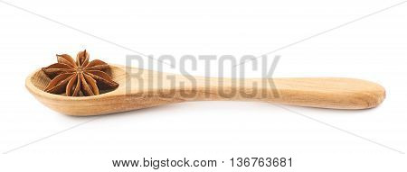Chinese star anise seed served in a wooden spoon, composition isolated over the white background