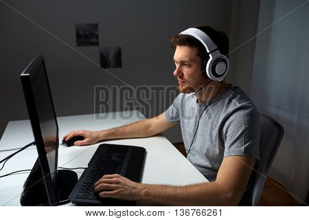 technology, gaming, entertainment, let's play and people concept - young man in headset with pc computer playing game at home and streaming playthrough or walkthrough video