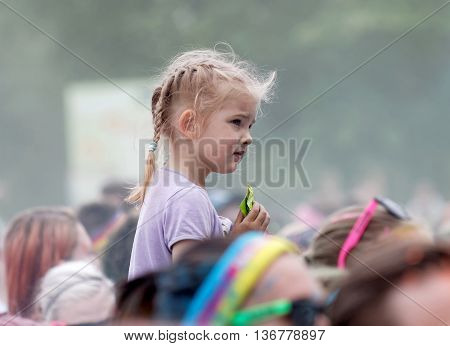 STOCKHOLM SWEDEN - MAY 22 2016: Young girl sitting on her fathers shoulders in the Color Run Event in Sweden May 22 2016