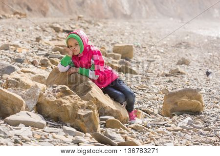 A Bored Tired Girl Lay Down On A Big Rock By The Sea