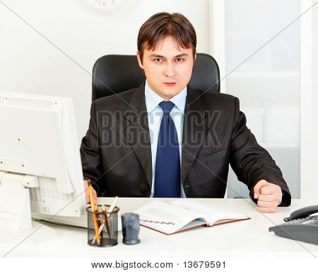 Dissatisfied modern business man banging fist on table