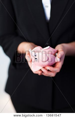 年轻商务女人持断的存钱罐