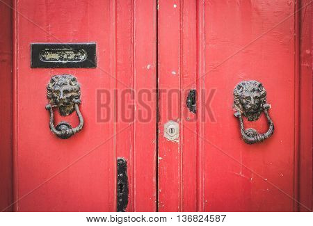 Old Red Wooden Doors with a Pair of Lion Head Metal Knockers in Mdina Malta