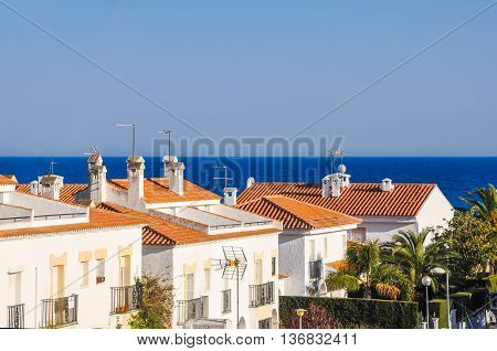 Small mediterranean snug resort town on Costa Dorada Spain. Chalets beside the sea. Summer vacations concept. Horizontal.