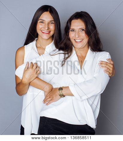 cute pretty teen daughter with mature mother hugging, fashion style brunette indoor