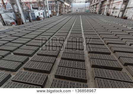 Stack of bricks. Manufacturing of aerated concrete blocks. Manufacturing of cinder block. The plant manufactures building material. The plant produces a cinder block. Cinder block-building material.