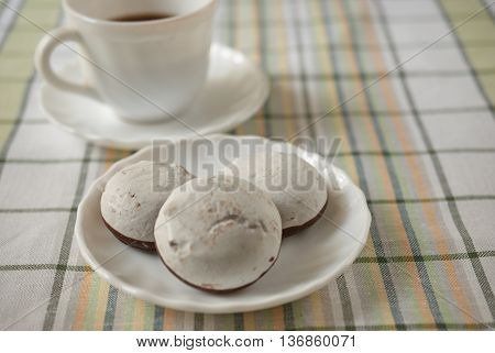 White cake in the foreground and a Cup of coffee