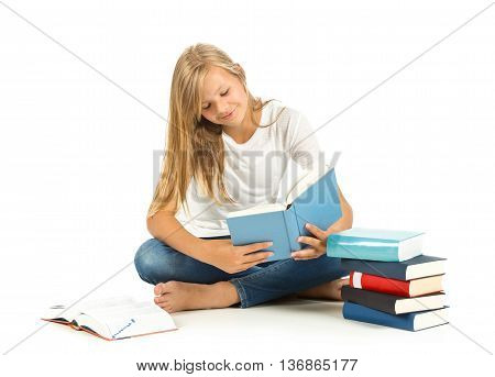 Young girl sitting on the floor with books reading over white background